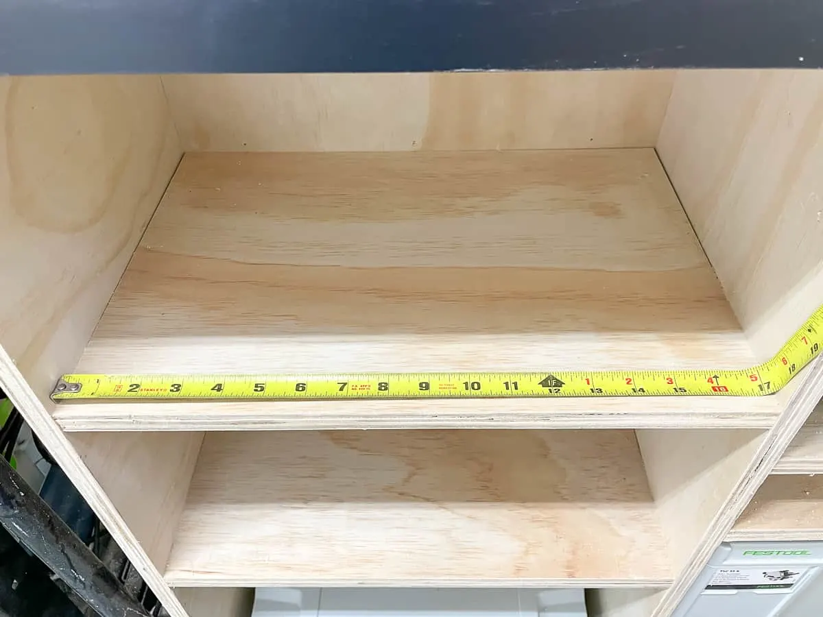 using a tape measure to find the interior measurement of a shelf by bending the tape