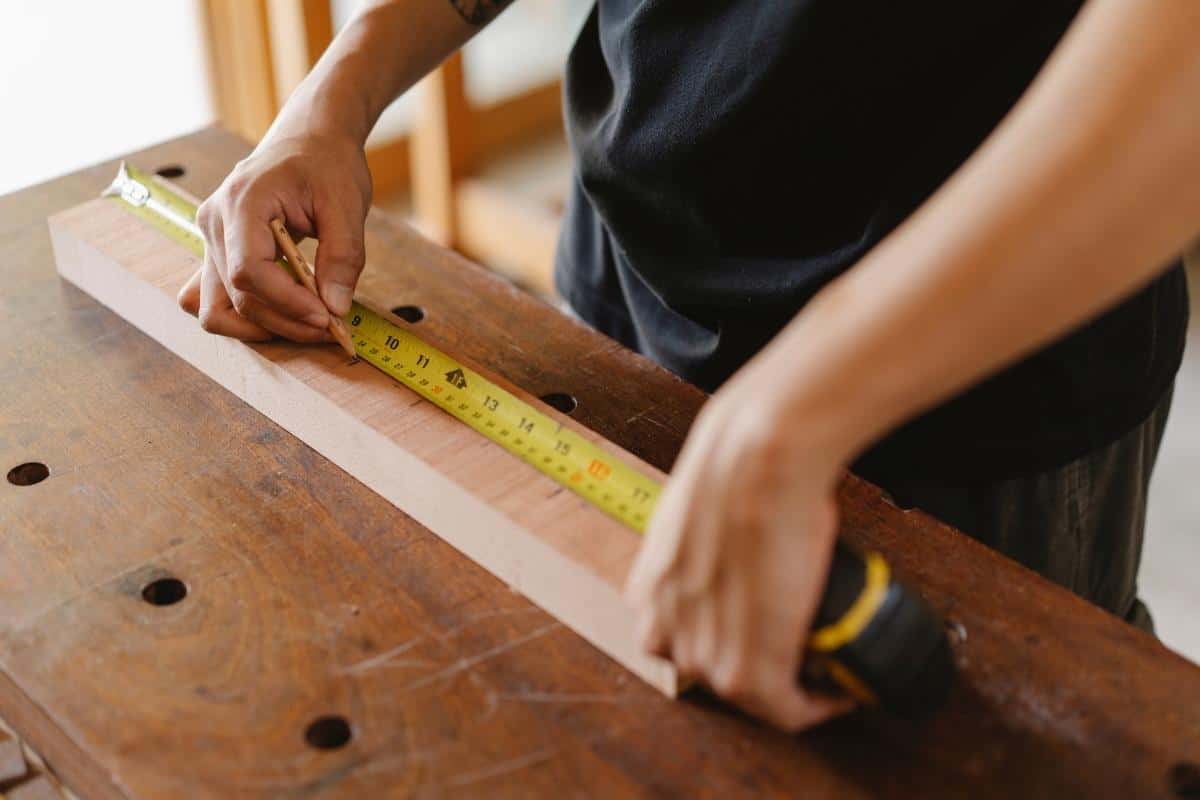 using a tape measure to mark a board for cutting