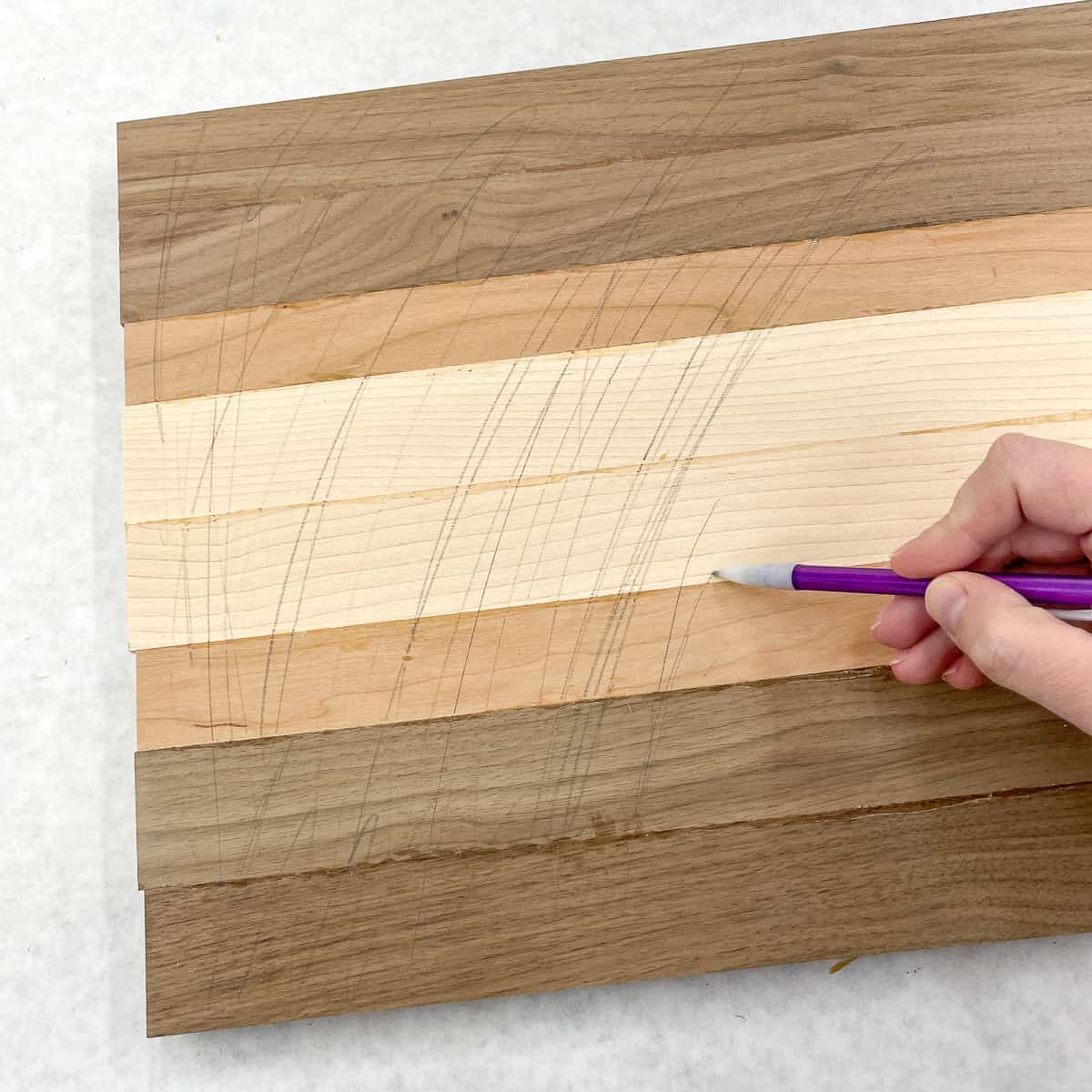 scribbling pencil lines over cutting board surface to aid with sanding