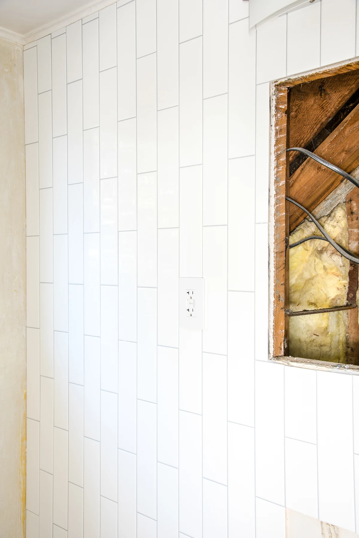 corner of the wall where the vertical subway tile meets the wall with a window