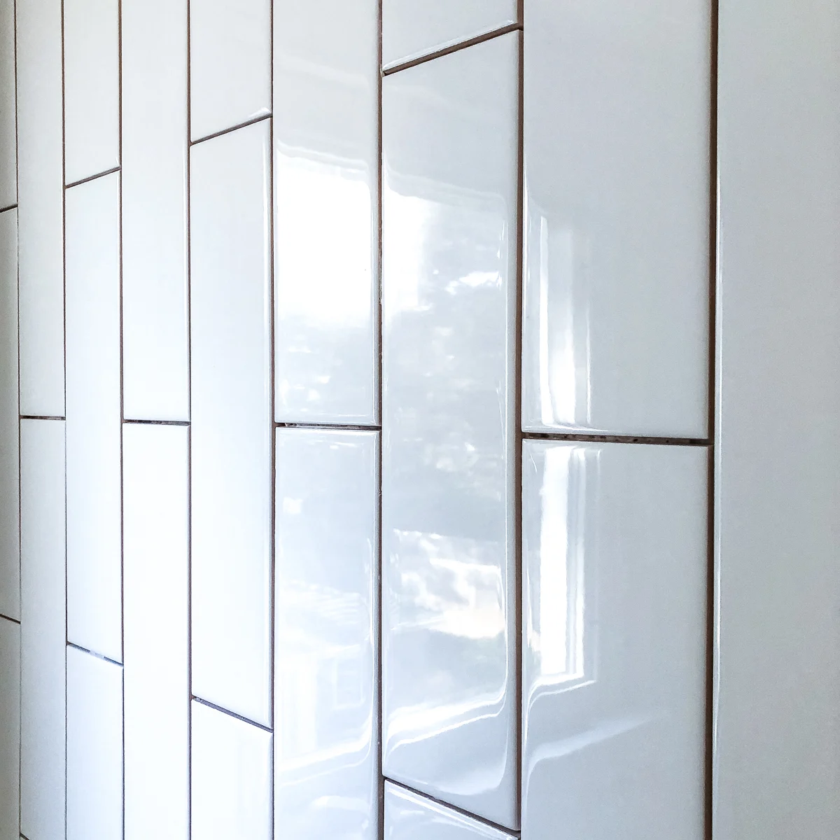 3"x12" long subway tile installed vertically on bathroom wall