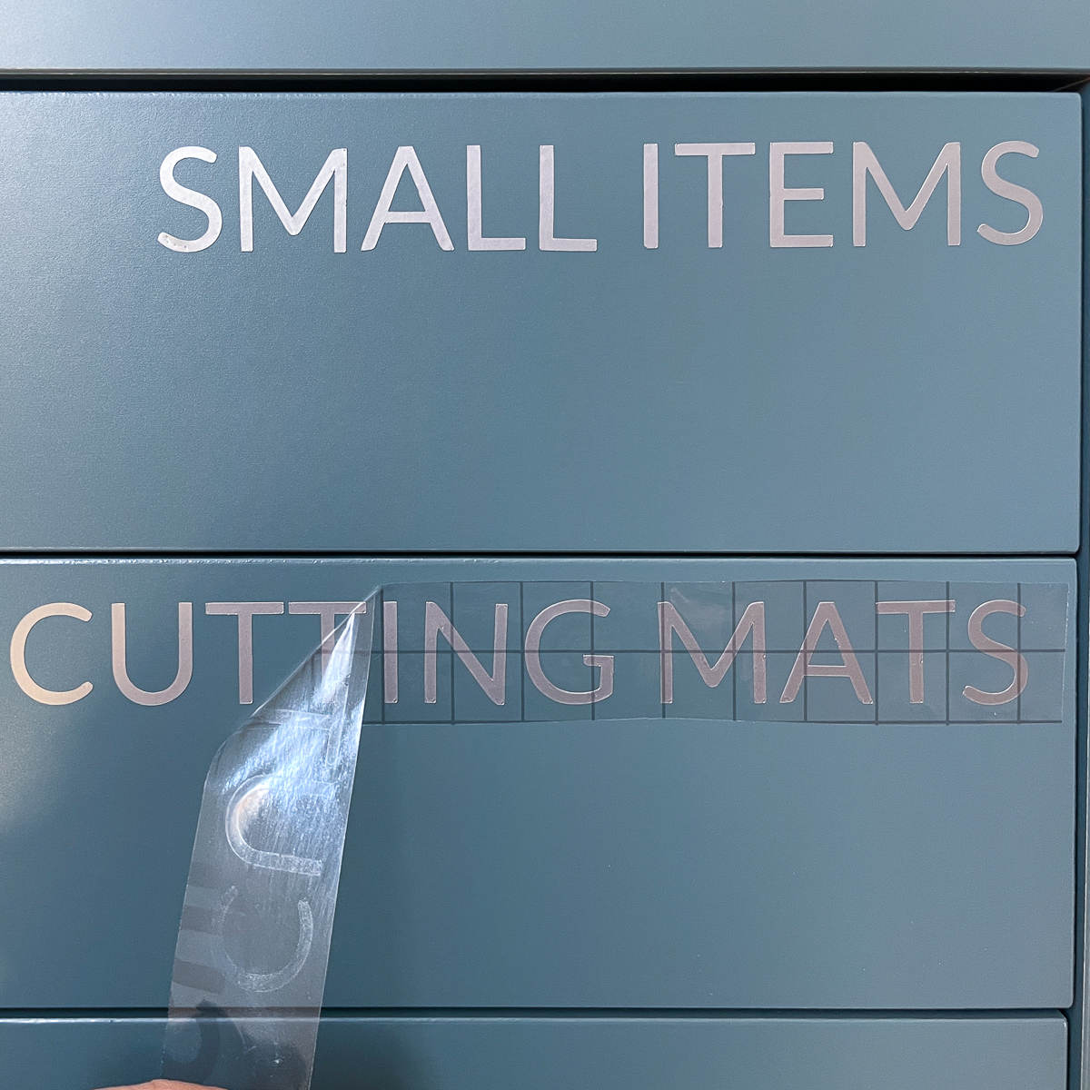 applying adhesive vinyl labels to drawer fronts