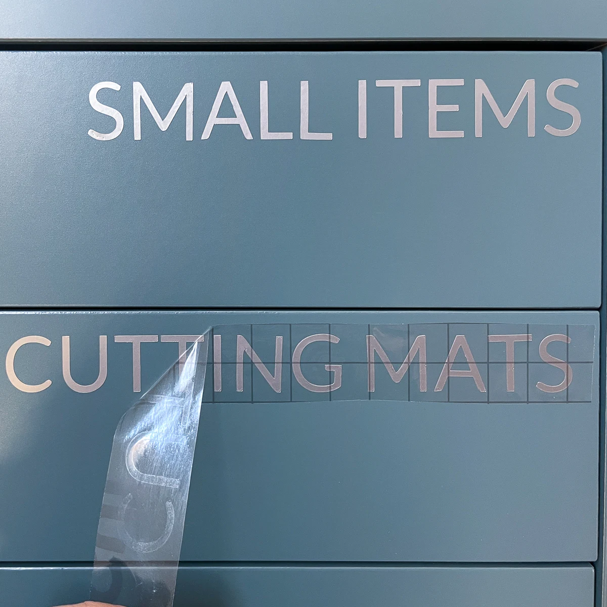 applying adhesive vinyl labels to drawer fronts