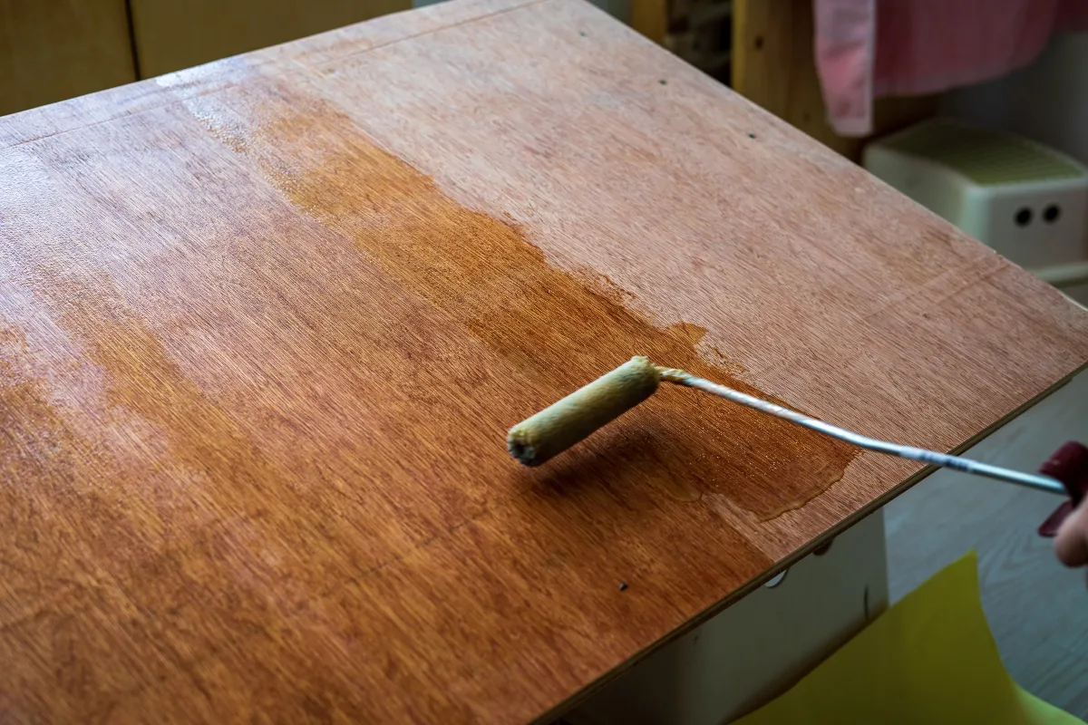 applying polyurethane to plywood sheet with a roller