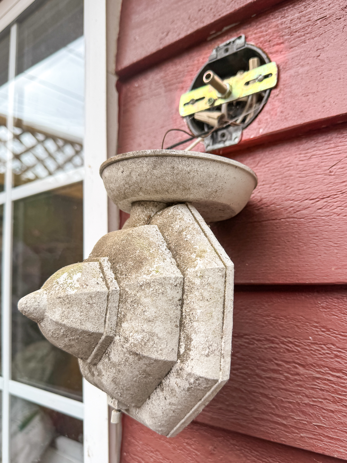 old outdoor light fixture hanging by wires after removing it from the mounting bracket