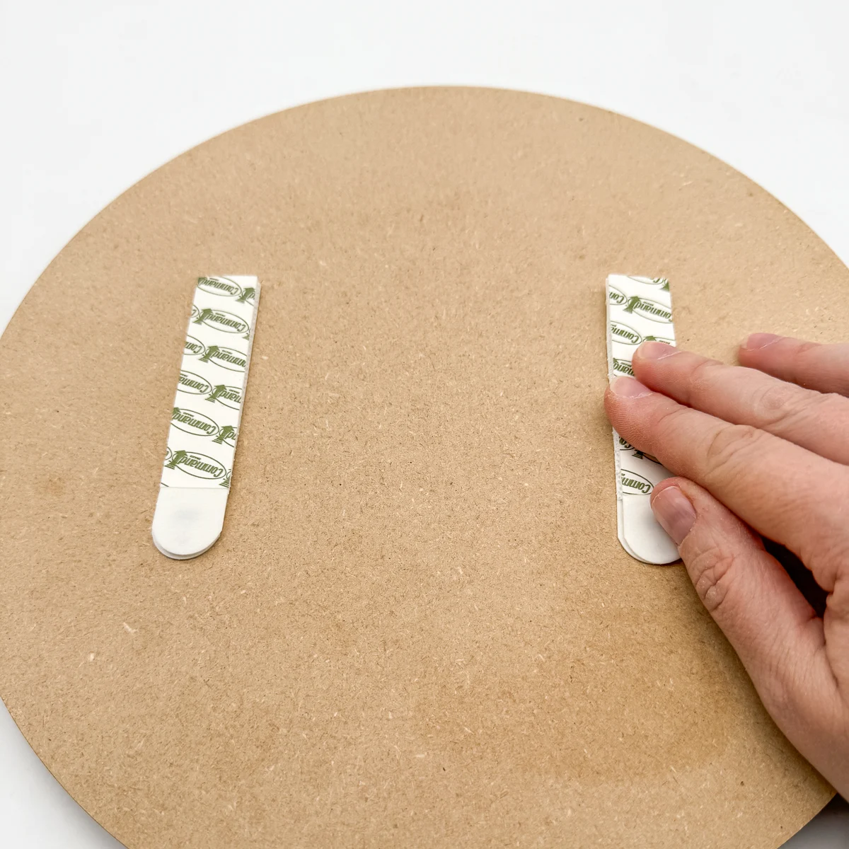 applying command strips to the back of the coin display