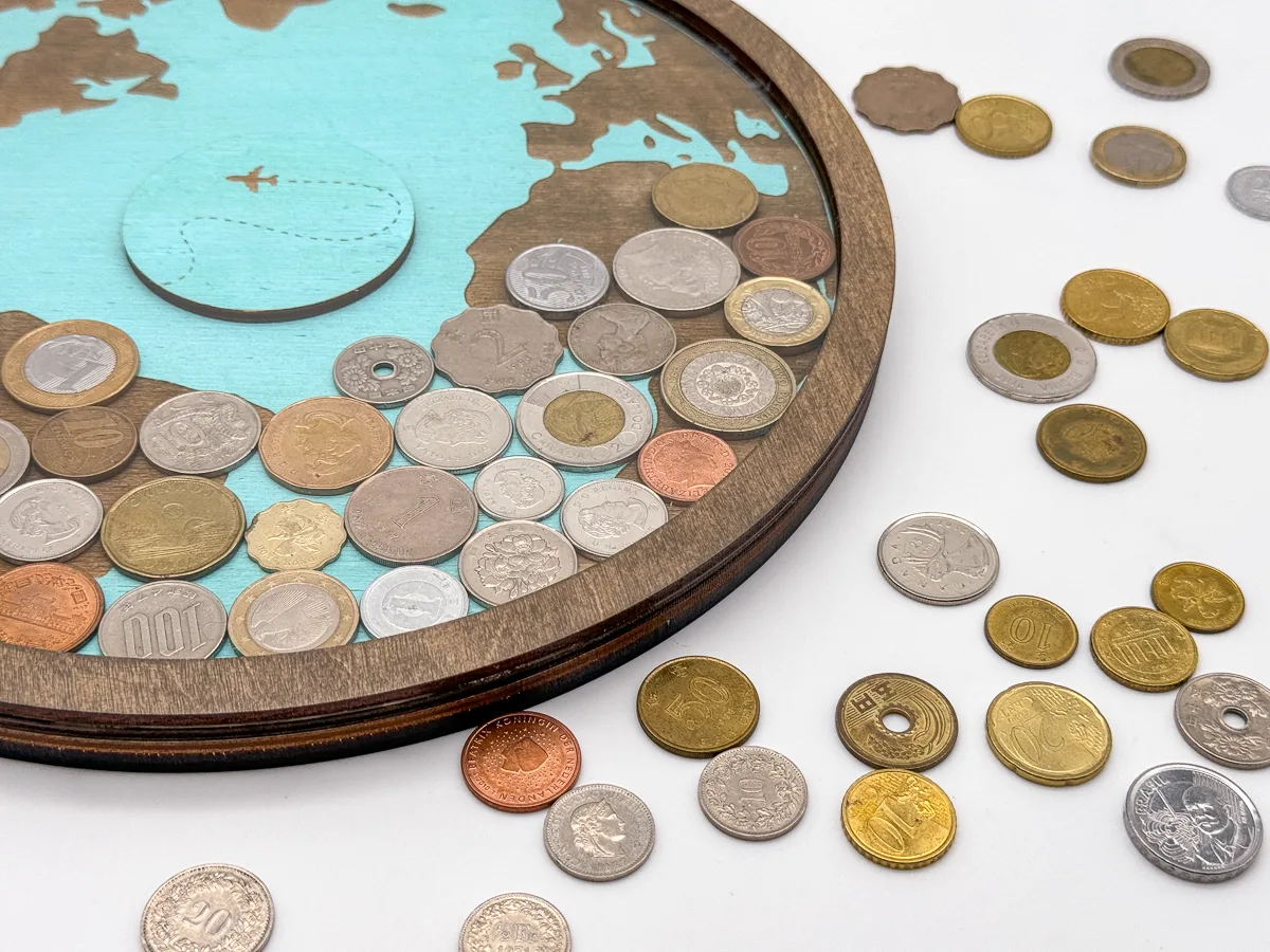 DIY coin holder with coins from different countries inside and on the table