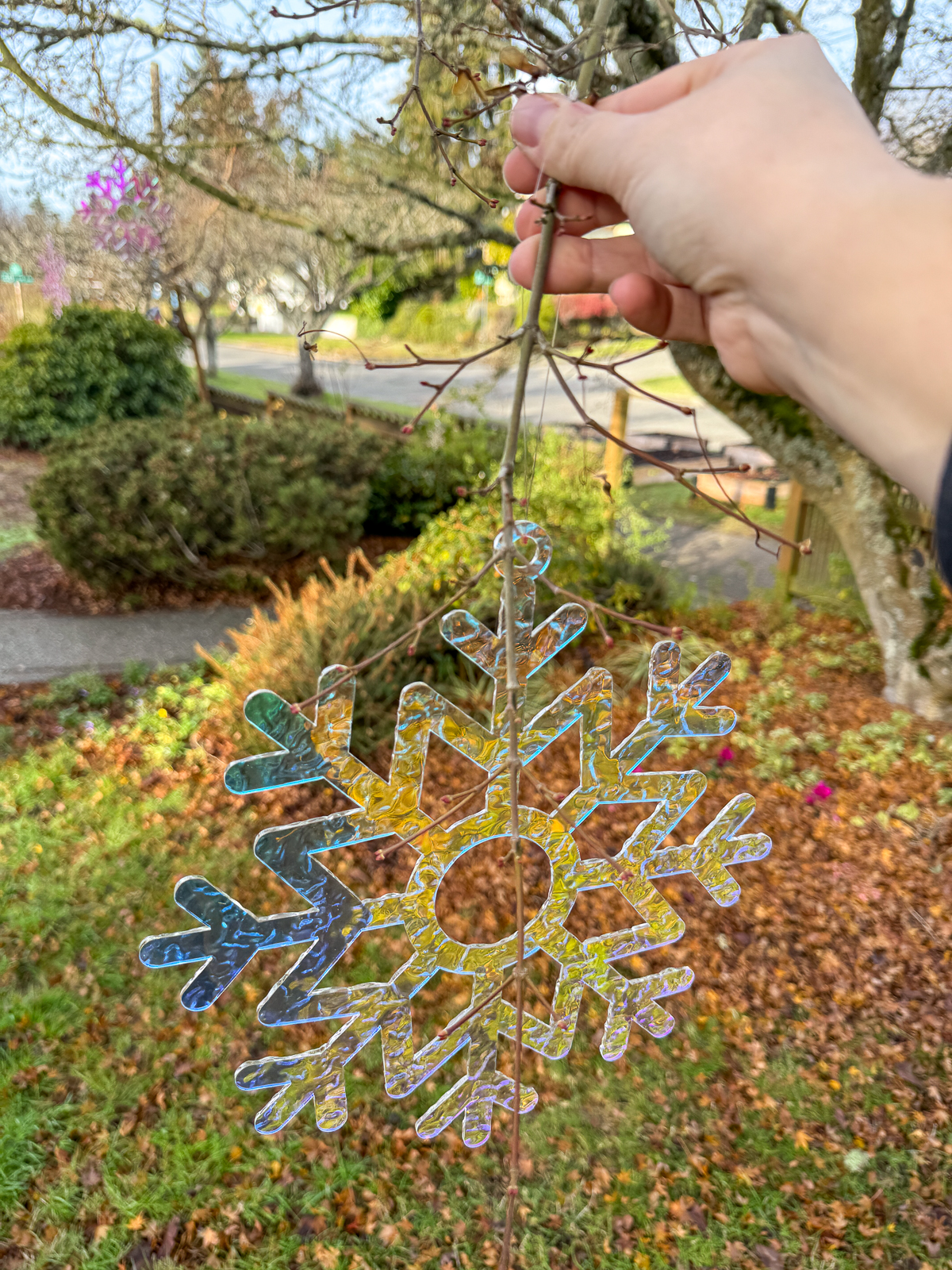 hanging DIY outdoor snowflake decorations in the tree