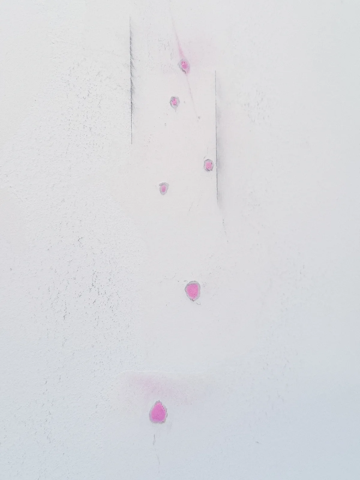drywall anchor holes filled with spackle that changes from pink to white when dry