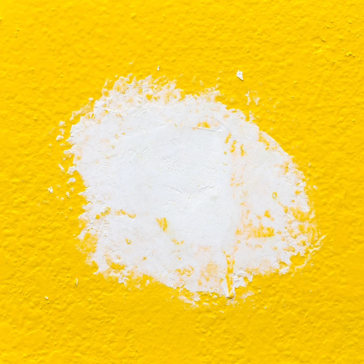 spackle over hole in yellow wall with different texture and sunken area