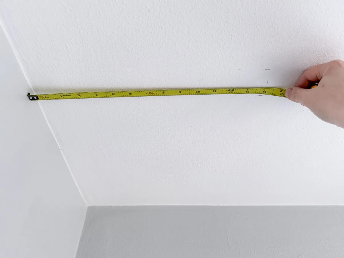 measuring the distance from the wall to the spot for the ceiling hook