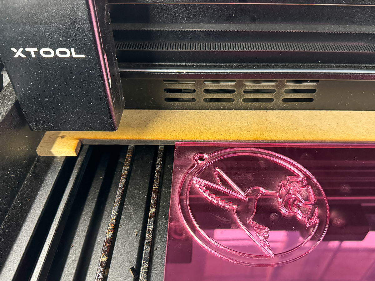 cutting a pink acrylic hummingbird suncatcher with the xTool P2 laser