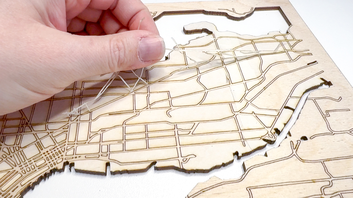 peeling away masking from roads on laser cut map before assembly