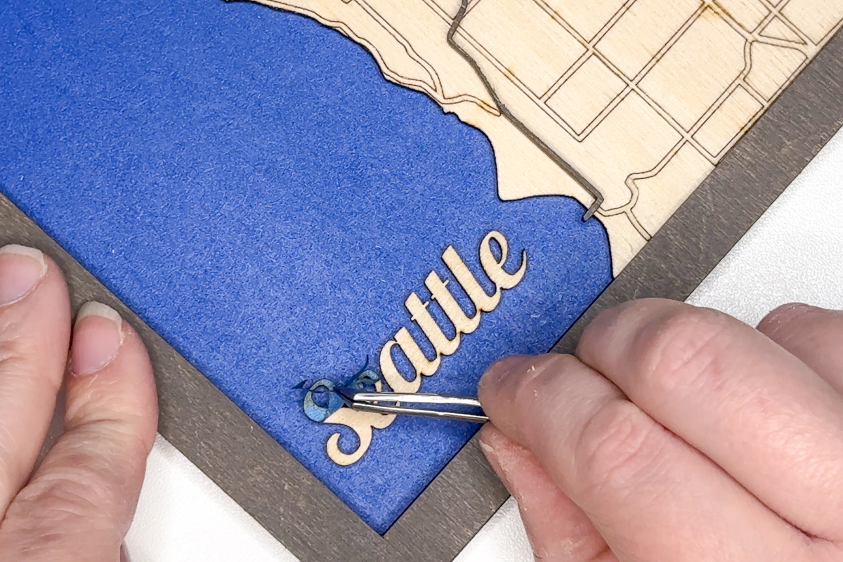 peeling the masking off the Seattle label on the laser cut map