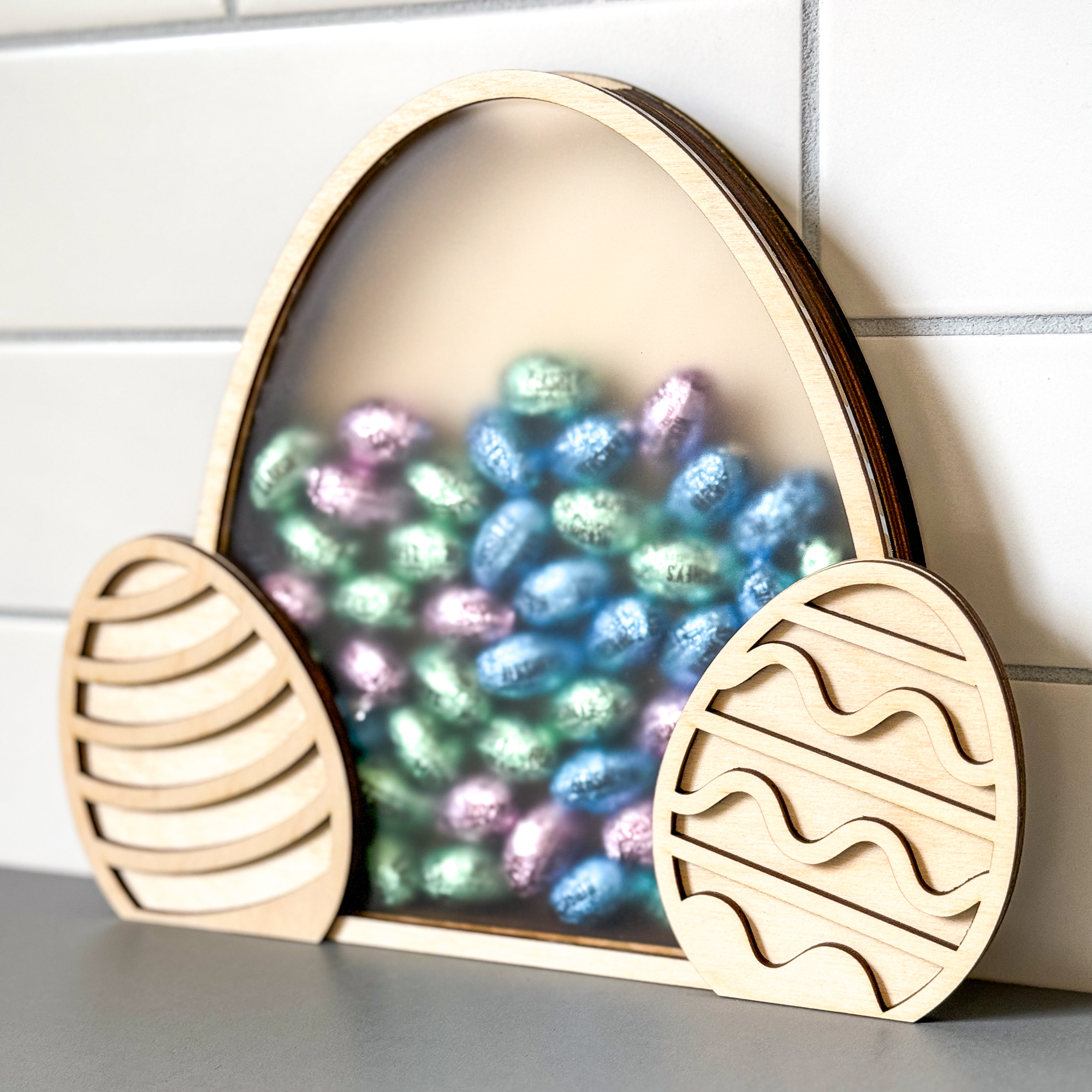 wood Easter candy holder with clear acrylic front in the shape of an Easter egg with Hershey chocolate eggs inside