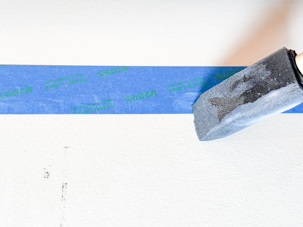 applying clear sealant to the painter's tape edge to ensure a straight paint line