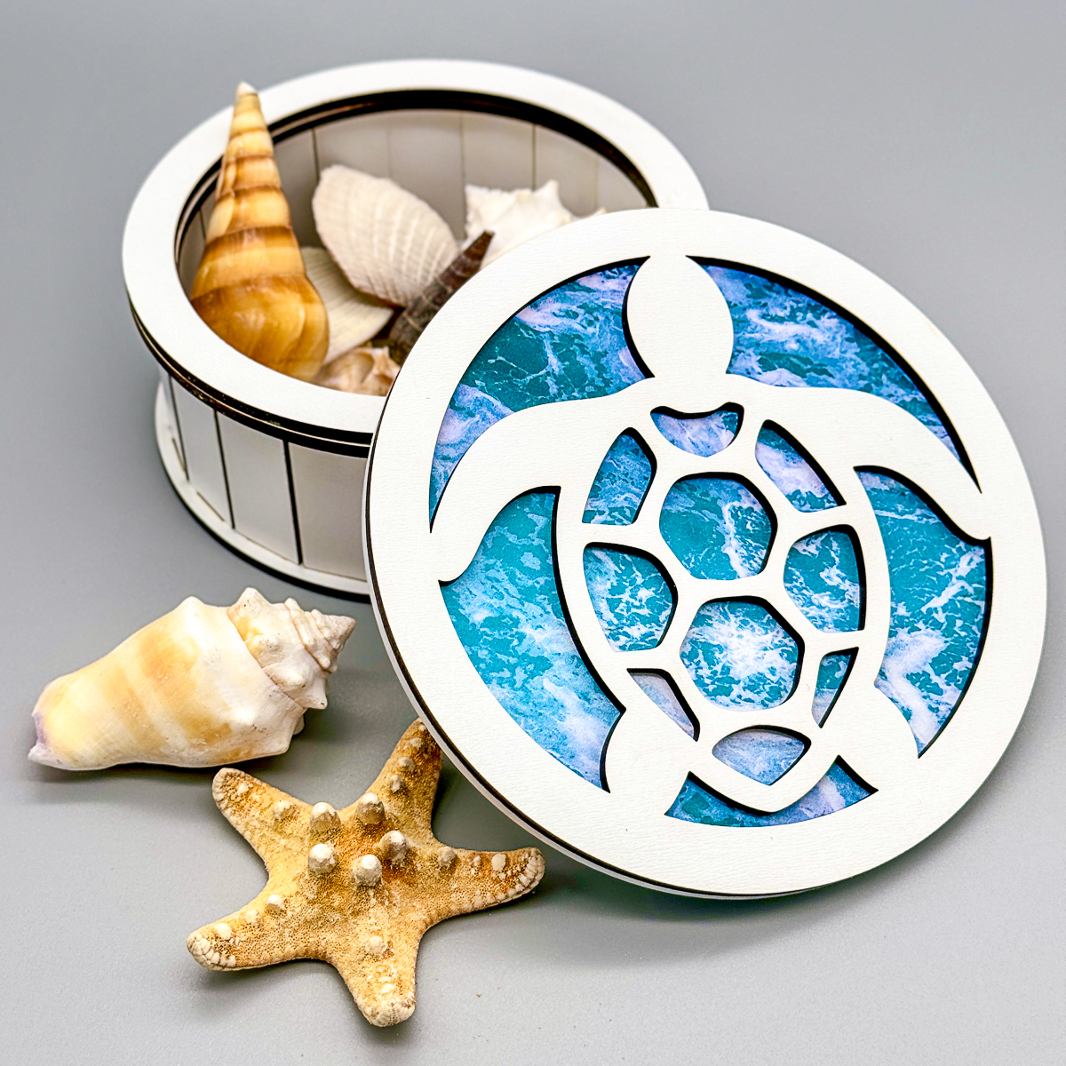 DIY round wood box with sea turtle design on lid filled with seashells
