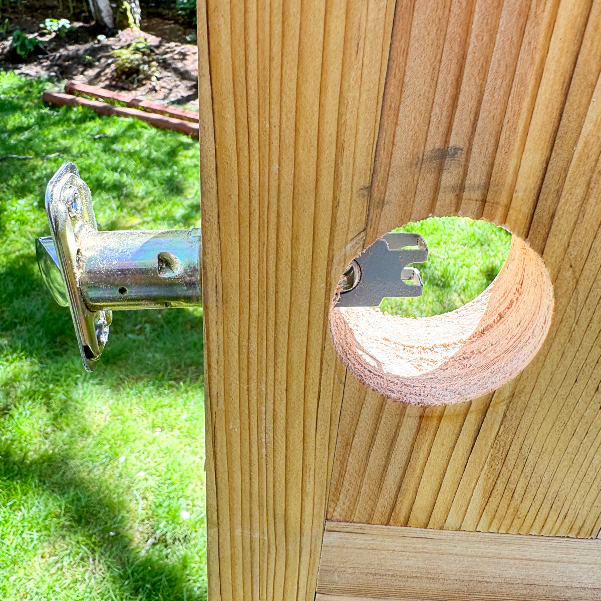 inserting the new door knob latch into the hole in the side of the door