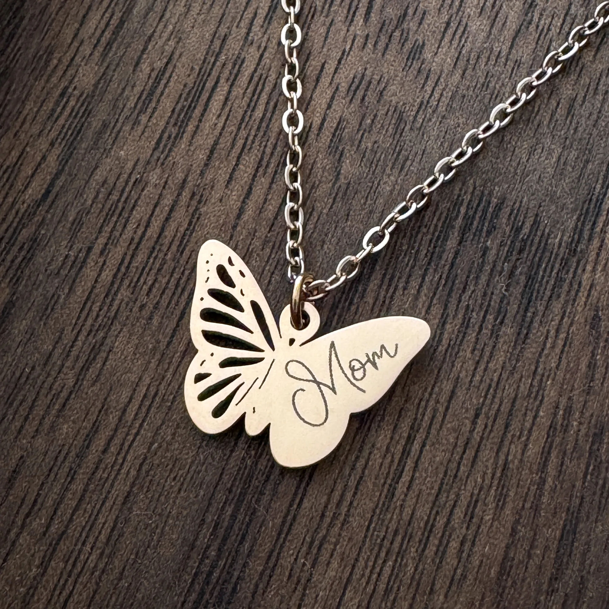 butterfly pendant with "Mom" engraved on one wing